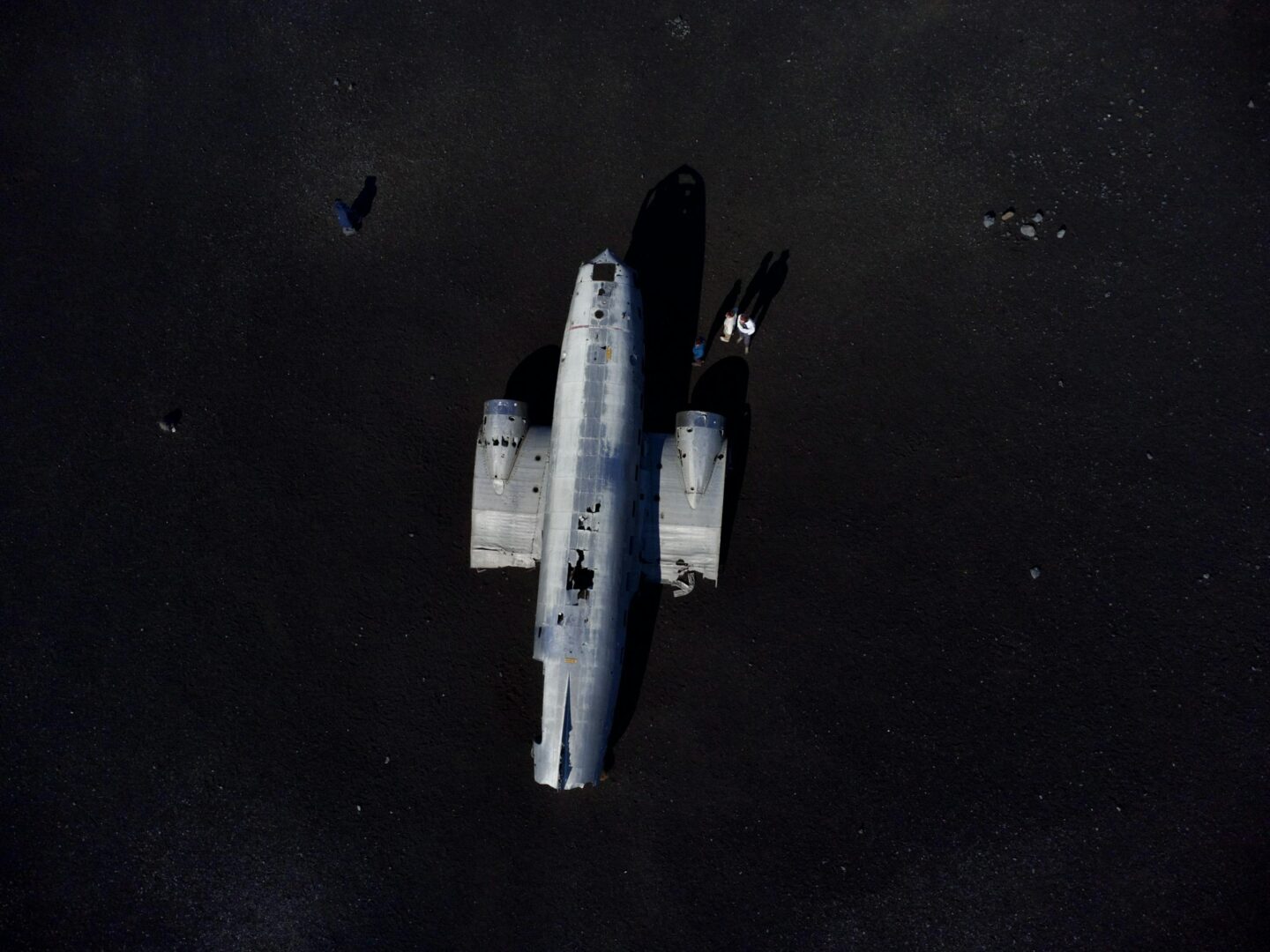 Aerial shot of a plane wreck on a barren landscape in Iceland.