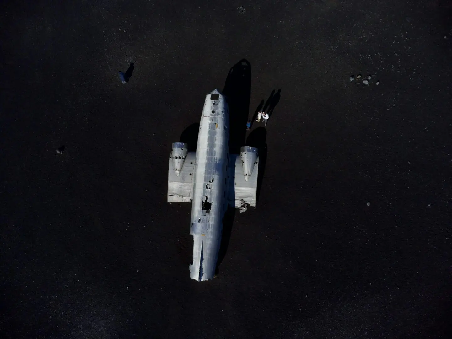 Aerial shot of a plane wreck on a barren landscape in Iceland.