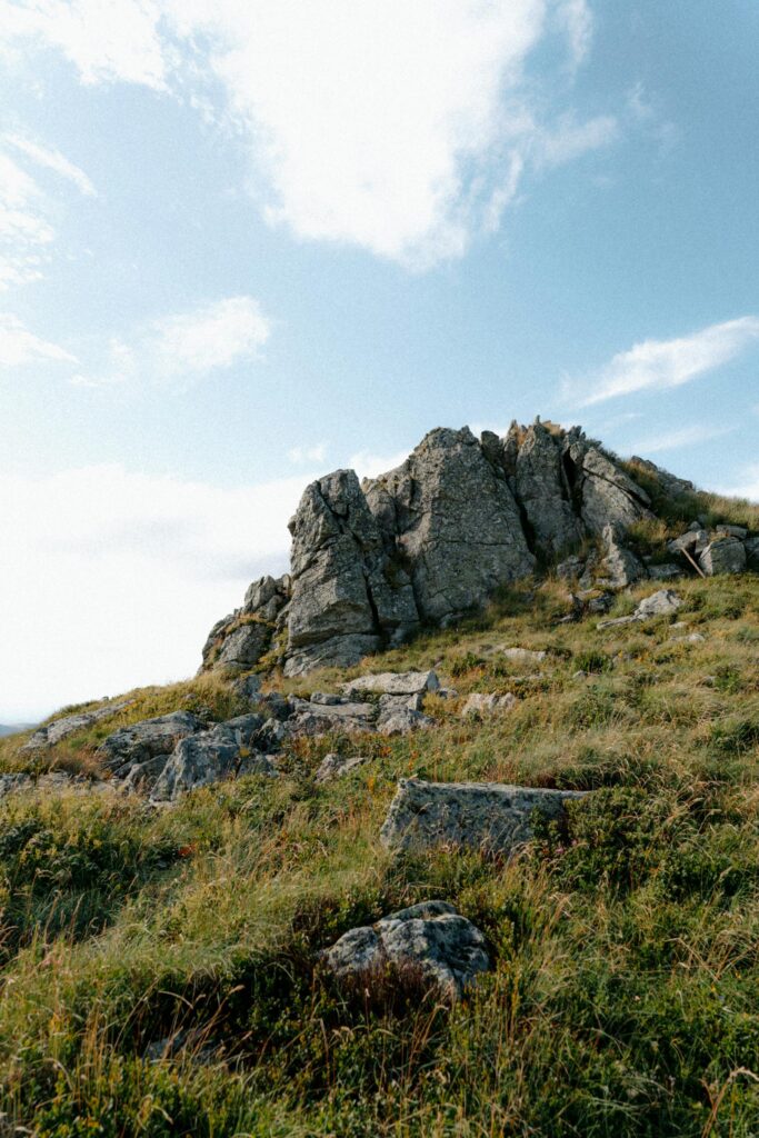 A picturesque rocky outcrop under blue skies in the Auvergne-Rhône-Alpes region. earth science exam